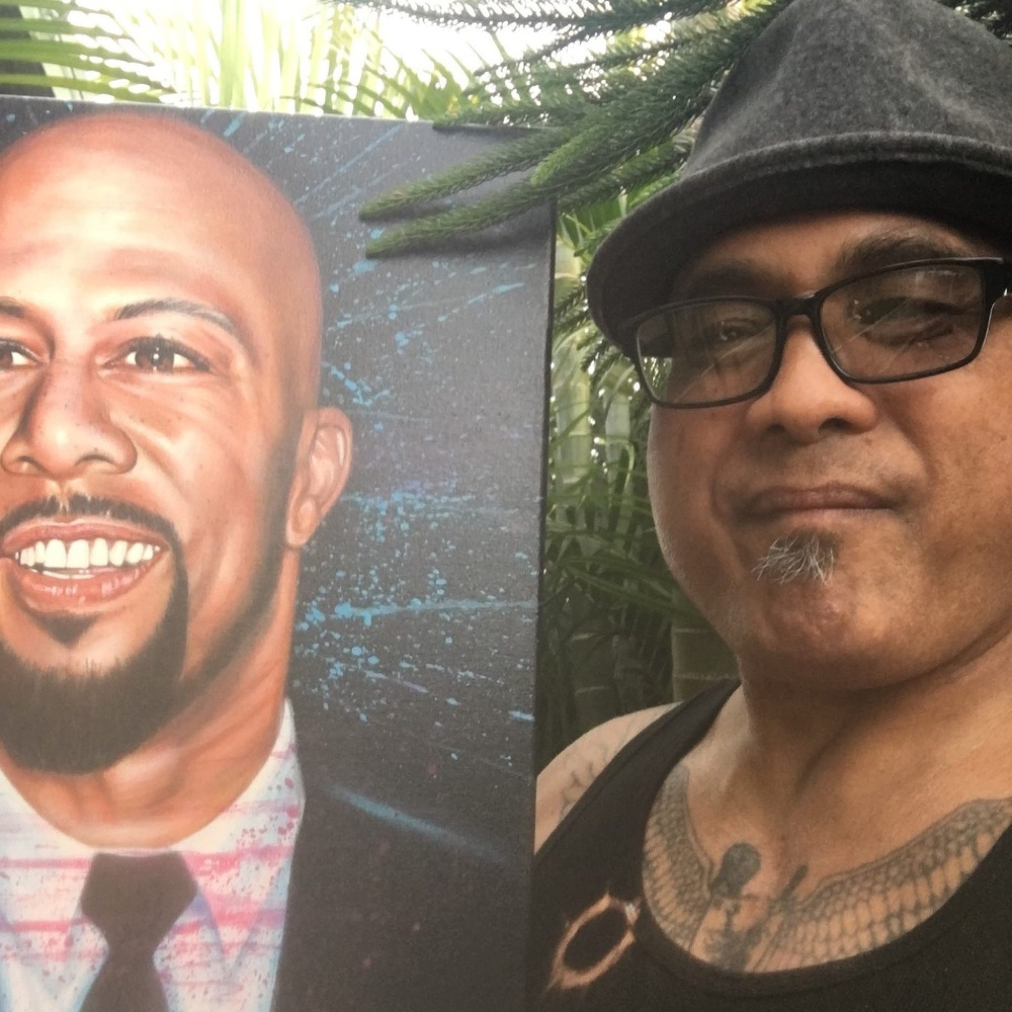 An image of a person formerly sentenced to LWOP holding a portrait painting of Common.